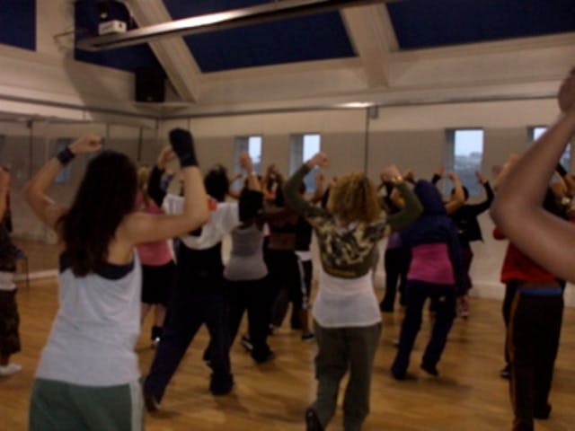 Dynamic group fitness class in a bright dance studio for wellness events and team-building.